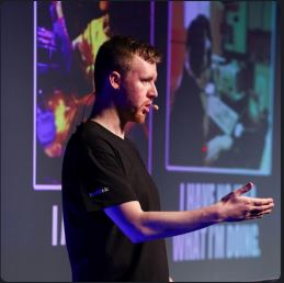 Paul Dragoonis speaking on stage at an engineering conference